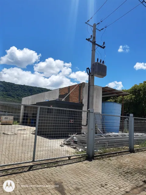 Transformador de 300 kVA no poste e abrigo de medição atrás da cerca
