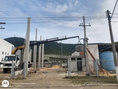 Caminhão guindaste posicionado junto ao poste para montagem da subestação