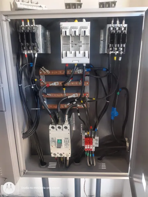 Painel aberto mostrando dispositivos de proteção e conexões internas