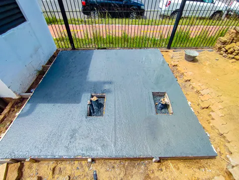 Base de concreto executada com aberturas para passagem dos cabos