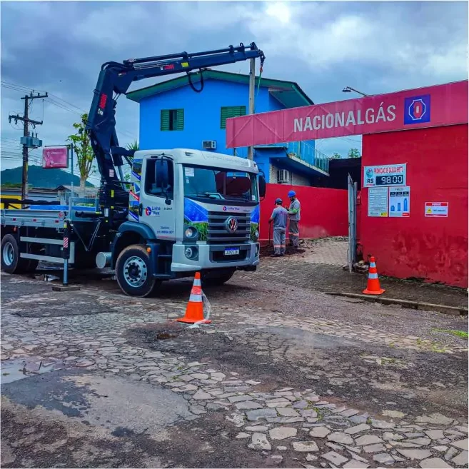 Caminhão guindaste do Grupo Linha Viva em frente a um estabelecimento comercial