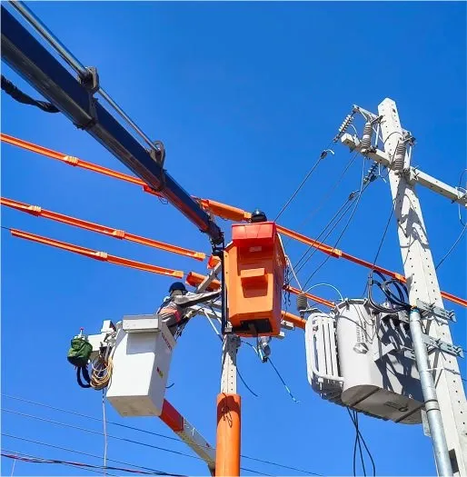 Cestos aéreos e profissionais trabalhando junto a um poste