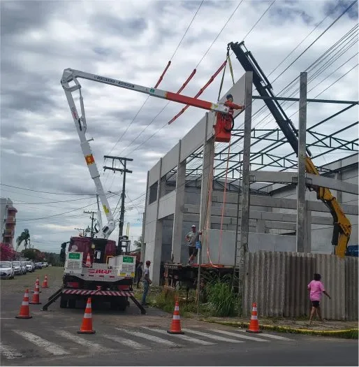 Cesto aéreo junto a uma estrutura metálica de entrada de energia