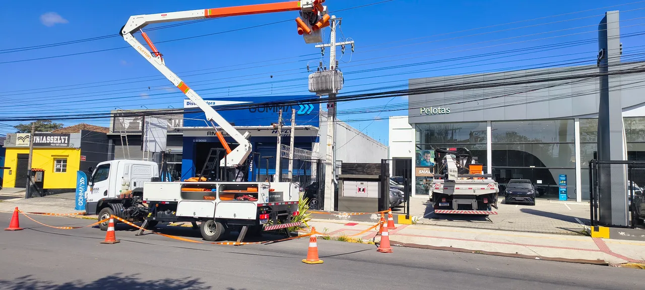 Caminhão com cestos aéreos em frente a uma edificação comercial