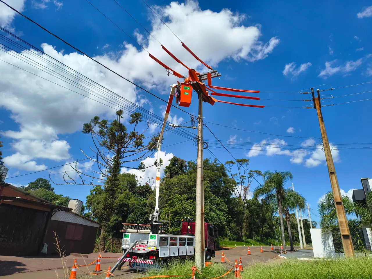 Poste com cestos aéreos e coberturas isolantes junto à rede elétrica
