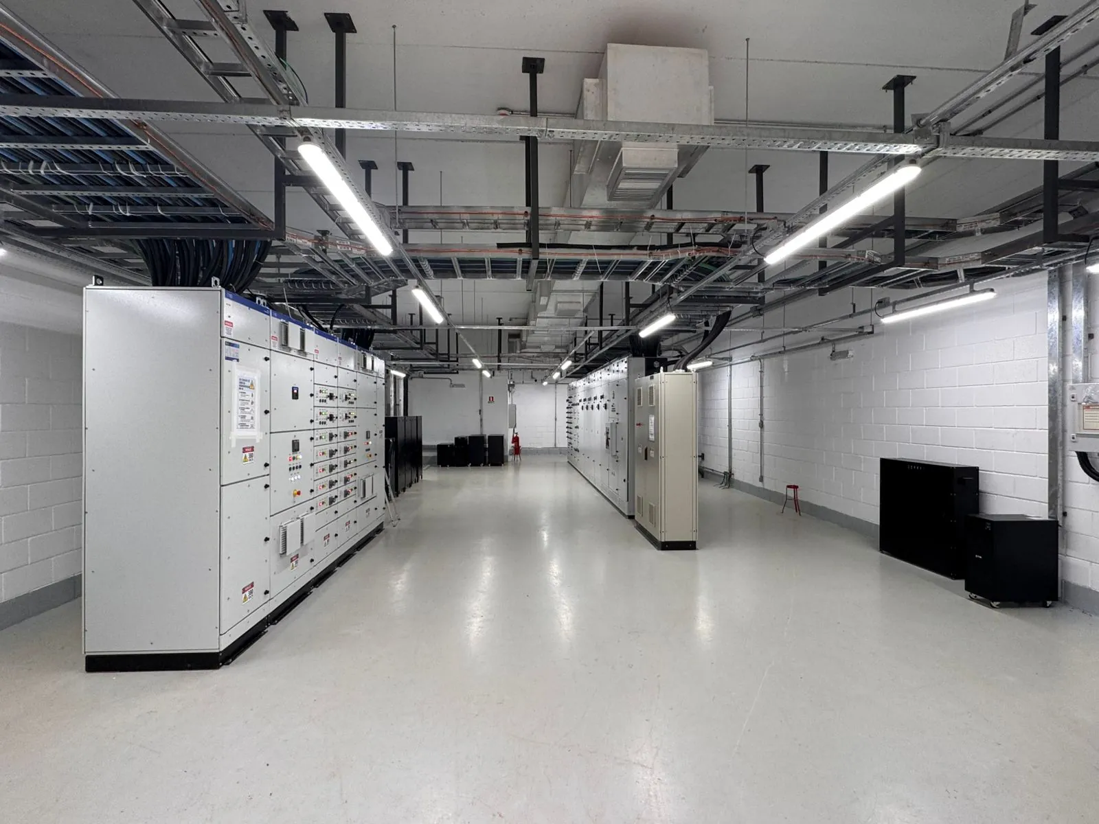 Sala elétrica com painéis de distribuição e infraestrutura de cabos em eletrocalhas