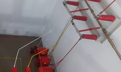 Isoladores e barramentos no interior de uma cabine elétrica